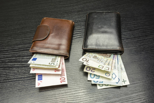 Portefeuilles met bankbiljetten van de Euro en de Poolse Zloty. - Foto, afbeelding