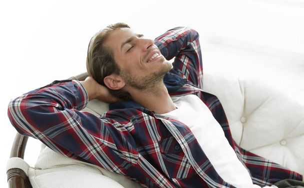 modern guy is resting sitting in a large comfortable chair. side view. - Photo, Image