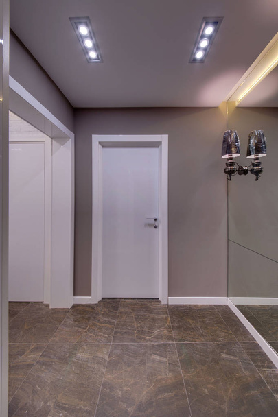 Corridor with white doors, a dark floor and a big mirror in a floor - Foto, imagen