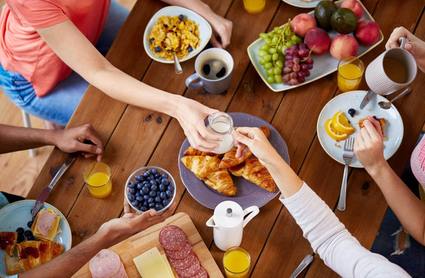 people having breakfast at table with food - Foto, Bild