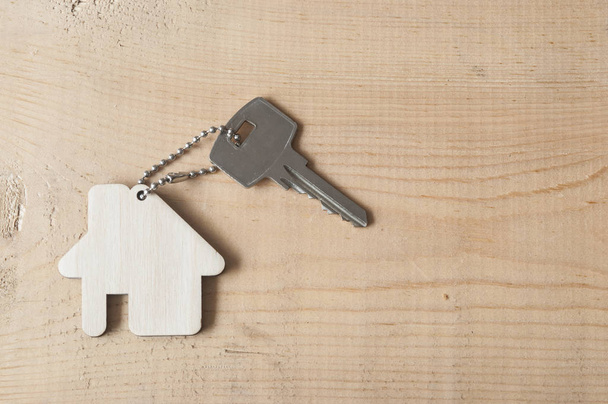Key with house icon on wooden background  - Photo, Image
