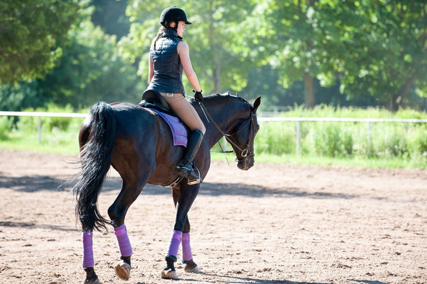 Nuori nainen ratsastaa hevosella ratsastuskoulussa. Koulutusprosessi
 - Valokuva, kuva