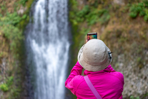 Tourist taking a picture of waterfalls - Fotó, kép