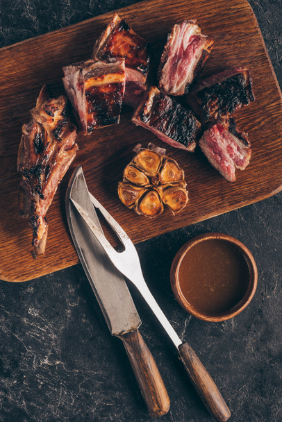 ブラック フォーク、ナイフとソースでおいしい焼き肉の上から見る - 写真・画像