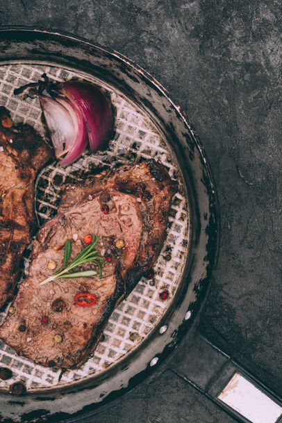 vista superior de la deliciosa carne asada en sartén con especias en negro
 - Foto, Imagen