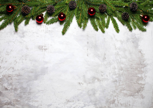 Christmas white background with fir branches and fir cones. Christmas wallpaper. Flat lay, top view - 写真・画像