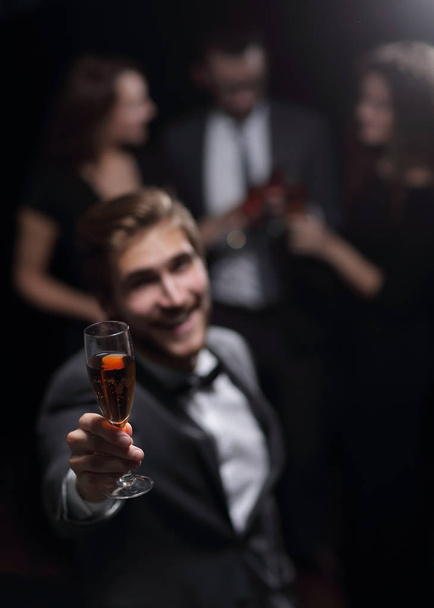 stylish young man raising his glass in a toast - Fotografie, Obrázek