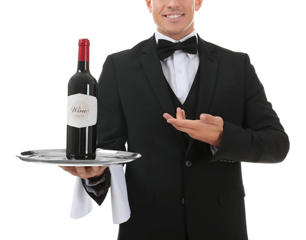 Waiter holding tray with bottle of wine on white background - Fotó, kép
