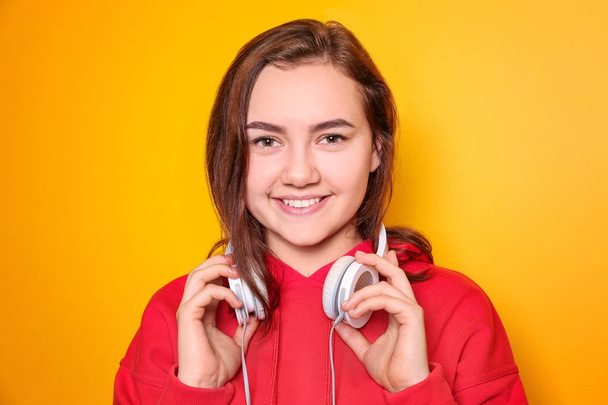 Beautiful smiling woman with headphones on color background - Foto, afbeelding