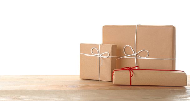 Parcel gift boxes on table against white background - Фото, изображение