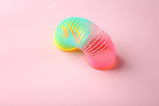 Rainbow slinky on color background. Toy for kids - Photo, image