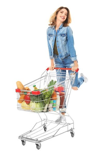 Young woman with full shopping cart on white background - Photo, image