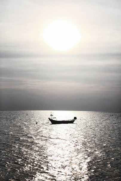 Lonely boat silhouette at Andaman blue sea in calm weather, Thailand - Valokuva, kuva