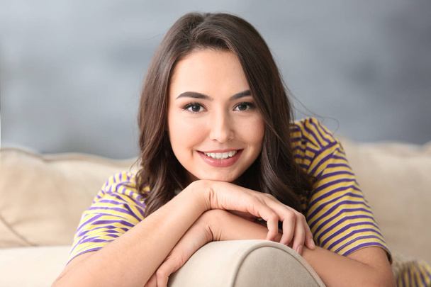 Young beautiful smiling woman resting on sofa at home - Фото, зображення