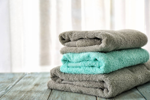 Stack of bath towels on table against light background - Zdjęcie, obraz