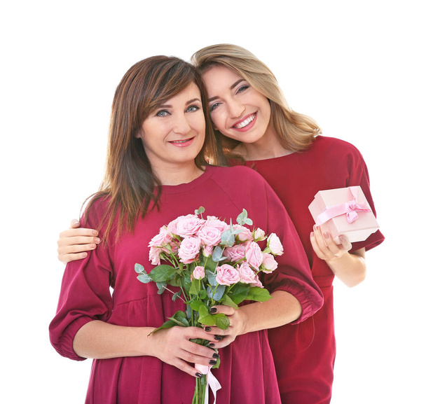 Attractive young woman with her mother in matching dresses on white background - Foto, Imagem