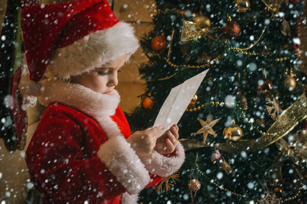 Santa claus kid at Christmas tree. - Foto, Bild