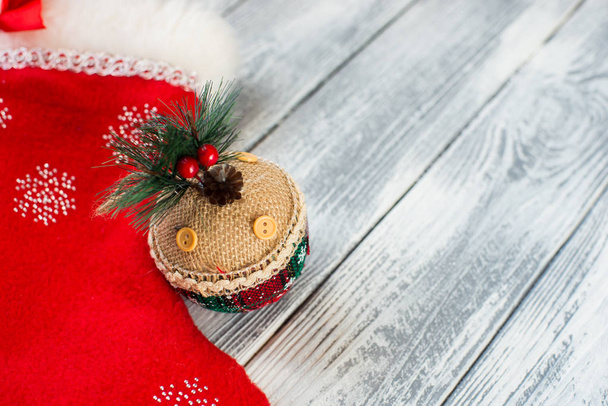 Gift with Christmas tape with a woolen red sock on a wooden background - Foto, Imagem