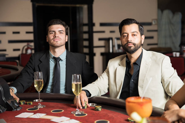 Retrato de dos jugadores de cartas masculinas apostando algunos y jugando a las cartas en un casino
 - Foto, Imagen