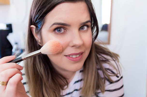 Žena použití make-up v její ložnici - Fotografie, Obrázek