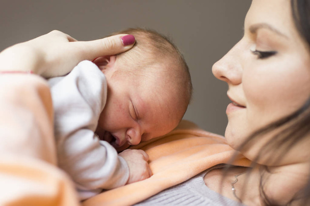 Hübsche Frau hält ein neugeborenes Baby im Arm - Foto, Bild