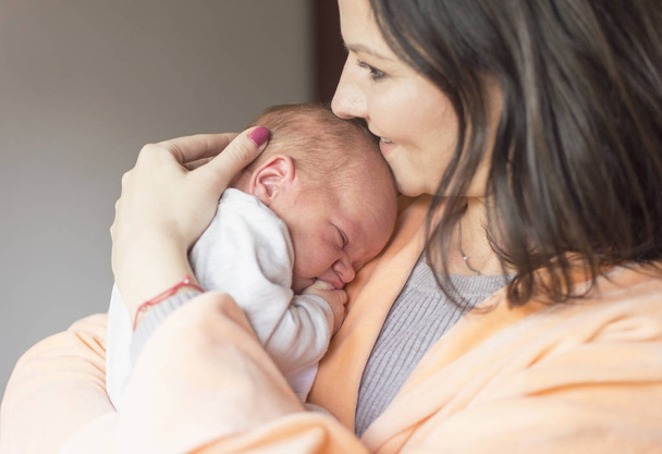 woman holding a newborn baby in her arms - Фото, зображення