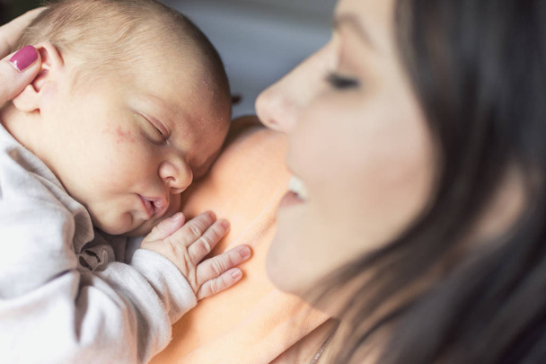 Красивая женщина с новорожденным ребенком на руках
 - Фото, изображение