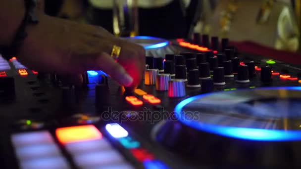 Közelről a dj party zene lejátszása a modern cd usb játékos disco club - éjszakai élet és a szórakozás koncepció. DJ lemezjátszó konzol mixer irányító két kezével szórakozóhelyen színpad - Felvétel, videó