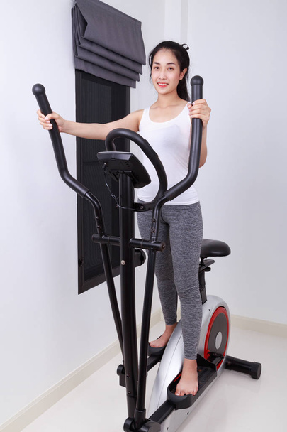 sporty woman doing exercises with elliptical trainer - Фото, зображення