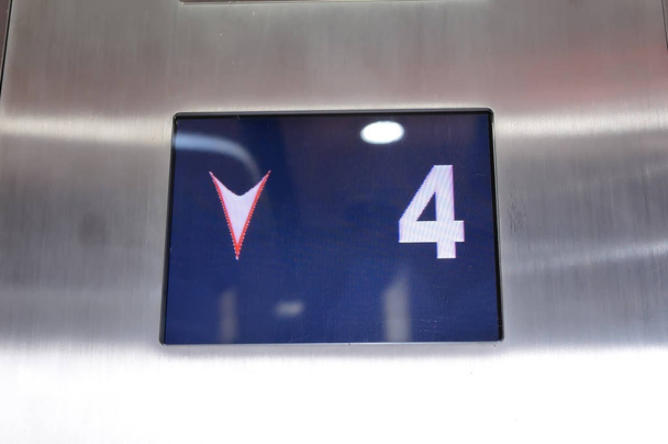 Pantalla digital que muestra el número de cuatro pisos dentro del ascensor
 - Foto, imagen