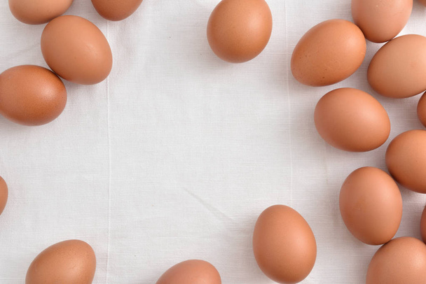 Fresh brown Eggs on white fabric background. - Photo, Image