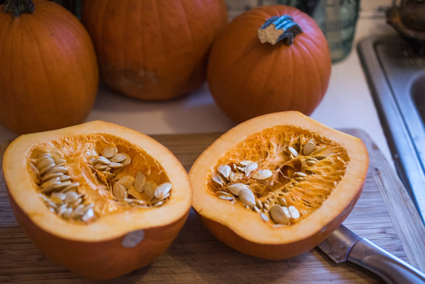 Sugar pumpkin cut in half exposing the pulp and seeds - Photo, Image