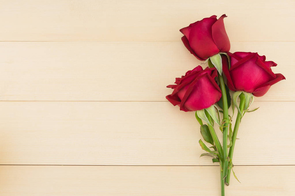 Bukiet czerwonych róż na jasnym tle drewna z miejsca kopii - Zdjęcie, obraz