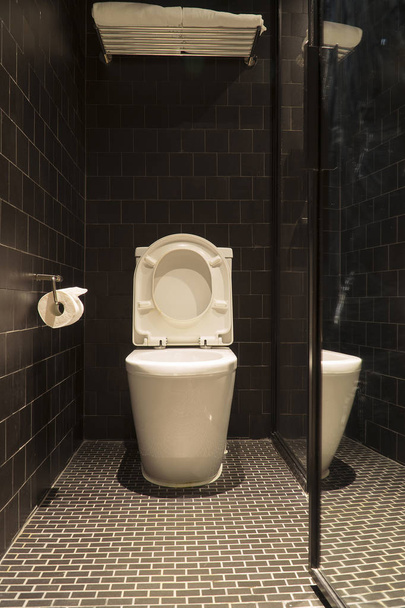 Czarne łazienki mają biały WC i biały ręcznik - Zdjęcie, obraz