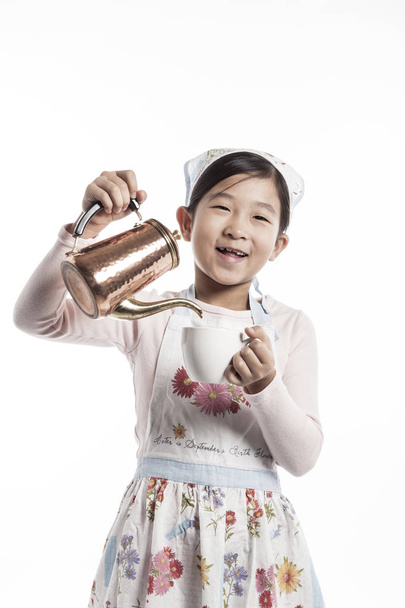 lindo asiático chica verter té en un taza
 - Foto, Imagen