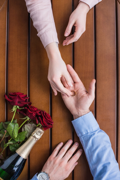 oříznutý obraz přítel navrhuje přítelkyni a dává snubní prsten - Fotografie, Obrázek
