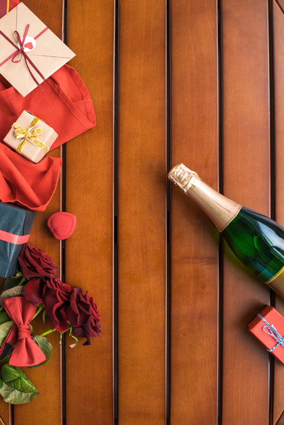 top view of champagne bottle with presents on wooden table  - Fotoğraf, Görsel