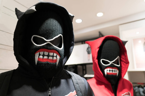 un masque de démons, un couple anorak en costume noir et rouge sur masque diable
 - Photo, image