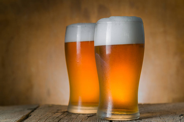 Beer in frosty mugs on rustic background - Photo, image