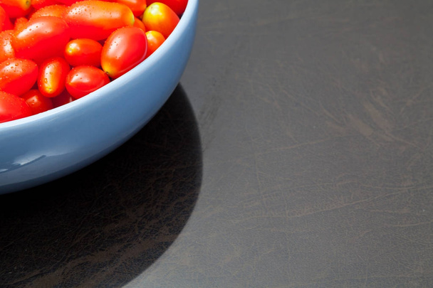 Tomates cerises de viol fraîches avec bol bleu
 - Photo, image