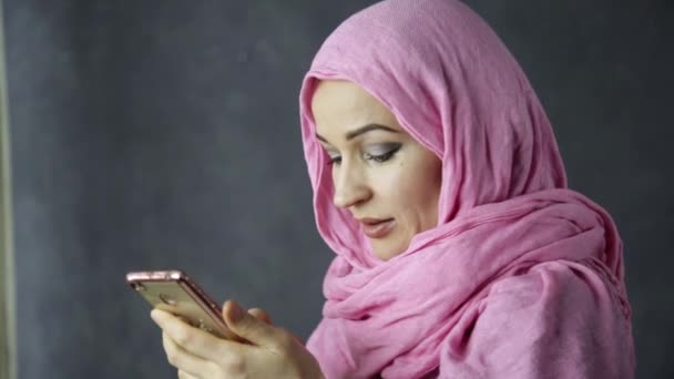 beautiful muslim woman in pink hijab talking on cell phone - Video, Çekim