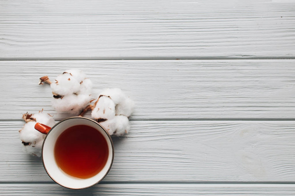 taza de té y flores de algodón sobre fondo oscuro
  - Foto, imagen
