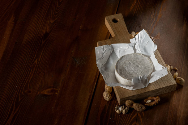 rustic flat lay with brie cheese on cutting board with nuts, top view with copy space - Valokuva, kuva