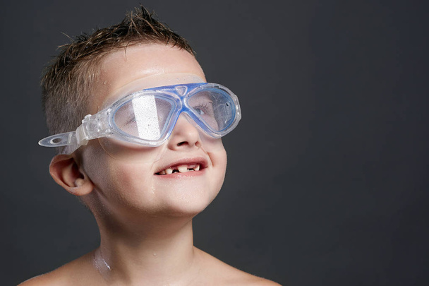 Улыбающийся мальчик в плавательной маске. мокрый ребенок
 - Фото, изображение