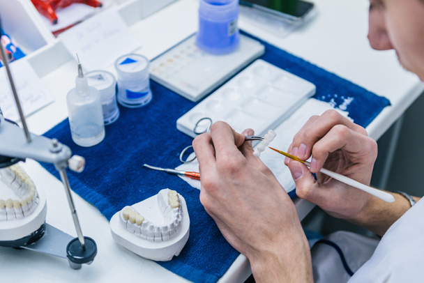 Zahntechniker oder Zahnarzt, der in seinem Labor mit Zahnersatz arbeitet - Foto, Bild
