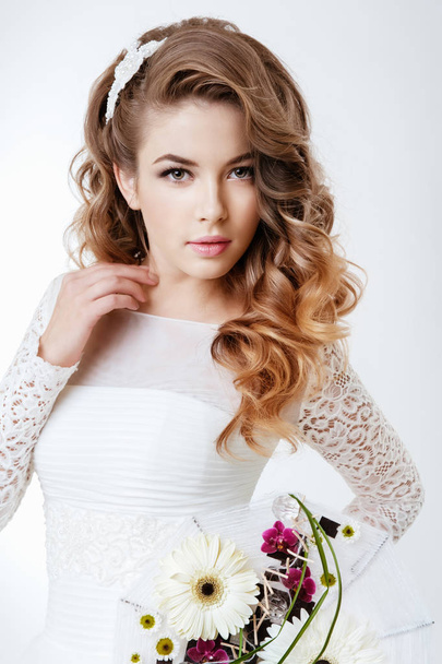 fashion portrait of young beautiful woman in white wedding dress posing with bouquet of flowers - Photo, image