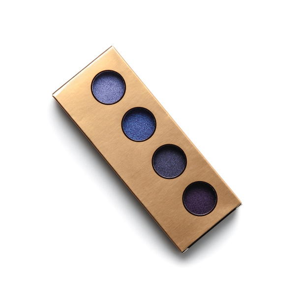 top view of golden container with different shaded purple eye shadows on white - Foto, immagini