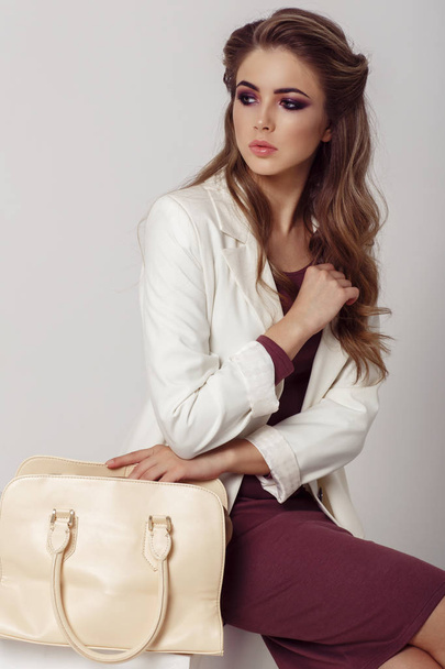 fashion portrait of young beautiful woman wearing stylish clothes over grey background  - Zdjęcie, obraz