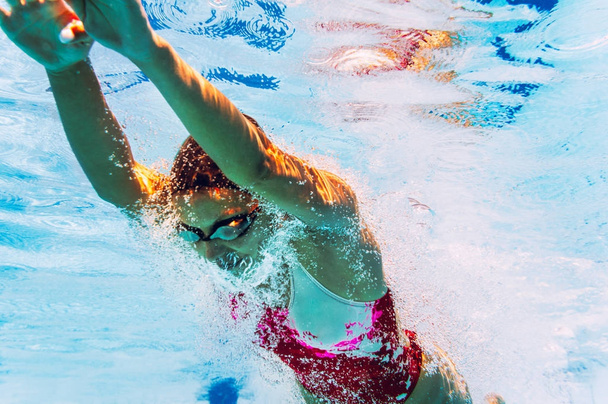 Young female diver in swimming pool, underwater shot  - Foto, Imagem