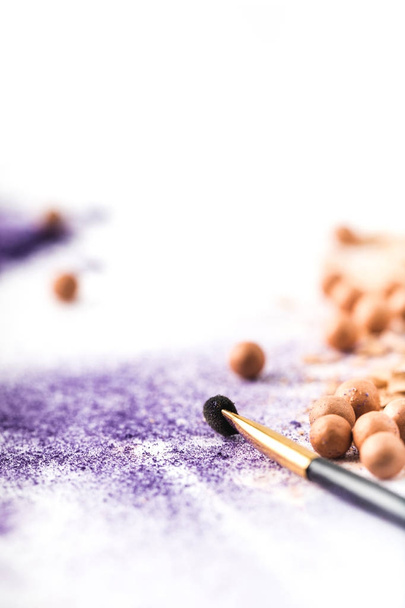 lähikuva laukaus violetti ja alaston kosmeettinen jauhe harjalla valkoisella pinnalla
 - Valokuva, kuva